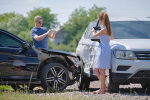 Stressed drivers taking picture on sellphone camera of smashed vehicles calling for emergency service help after car accident